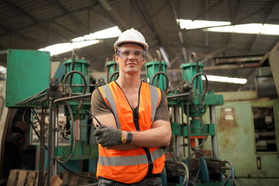 Portrait of young man standing in factory