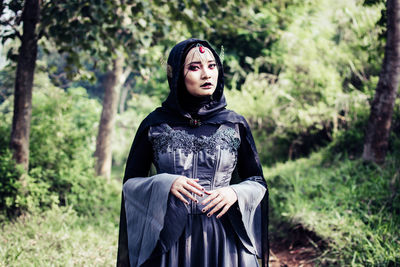 Young woman wearing witch costume while standing outdoors