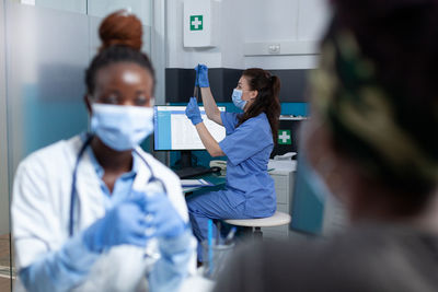 Doctor wearing mask talking with patient