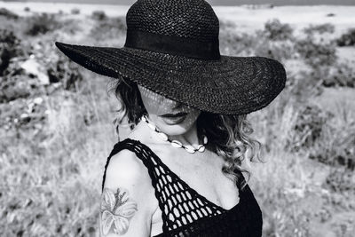 Portrait of woman wearing hat standing on field