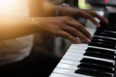 Midsection of pianist playing piano