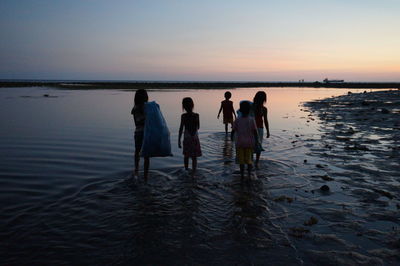 People at beach during sunset