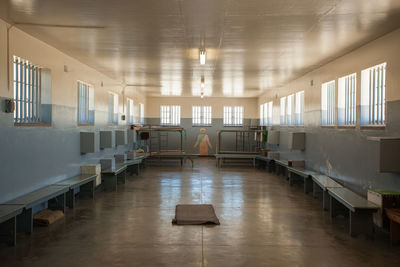 Man sitting in empty corridor of building