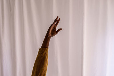 Cropped hand of woman against wall