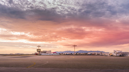 View of airport runway against sky during sunset