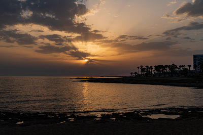 The sun casting rays of orange light over the coast line of paphos on the island of cyprus