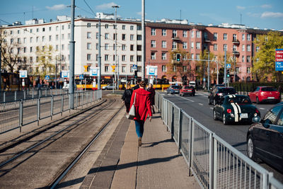 Rear view of man walking on street in city