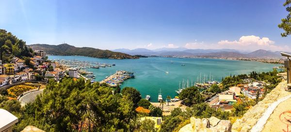 High angle view of sea and cityscape against blue sky