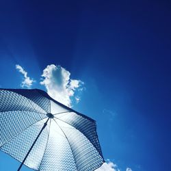 Low angle view of umbrella against blue sky