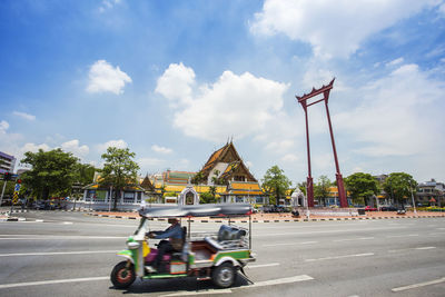 Cars on street in city against sky