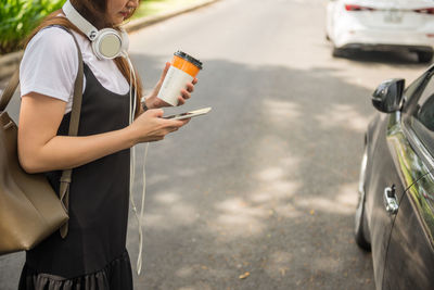 Midsection of woman holding car