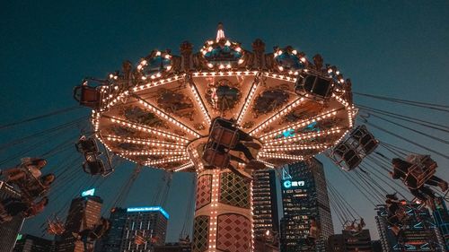 Low angle view of illuminated ferris wheel against sky at night