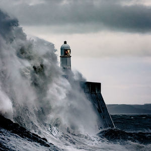 Lighthouse by sea against sky