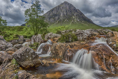 Scenic view of waterfall against sky