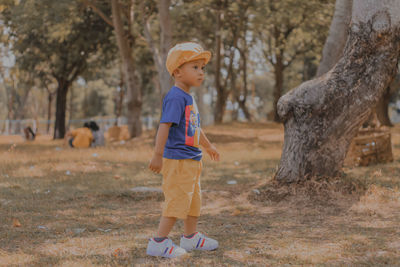 Full length of boy standing in forest