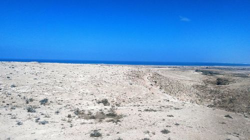 Scenic view of beach against clear blue sky