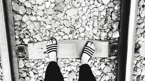 Low section of man standing on railroad track