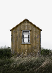 House on field against clear sky