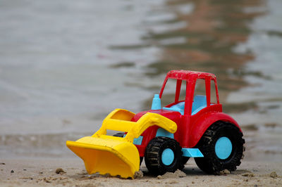 Toy excavator at lakeshore