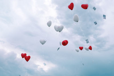 Low angle view of balloons flying against sky