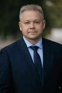 Portrait of businessman standing against blurred background