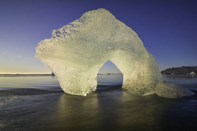 View of rock formation in sea against sky