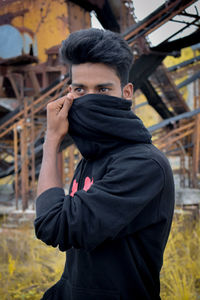 Young man looking away while covering face