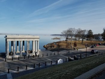 Built structure by sea in city against sky