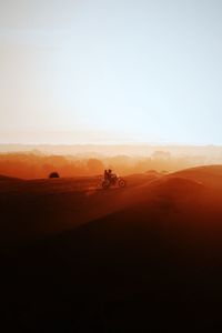 Scenic view of desert against clear sky during sunset