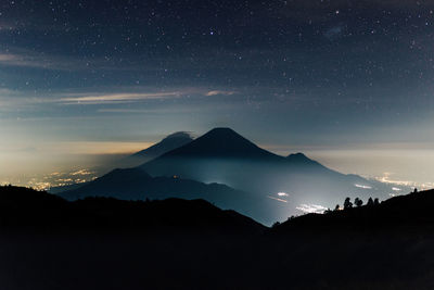 Scenic view of silhouette mountains against sky at night