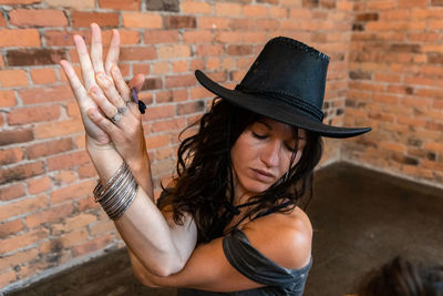 Portrait of woman wearing hat against wall