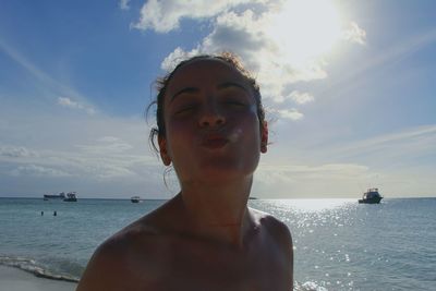 Portrait of shirtless man in sea against sky