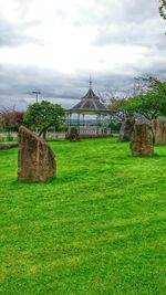 View of grassy field against cloudy sky