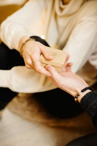 Midsection of woman holding hands at home