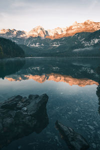 Scenic view of lake by mountains against sky