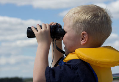 Rear view of boy photographing