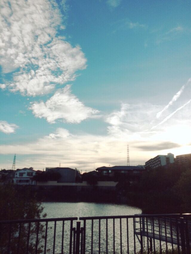 built structure, architecture, building exterior, sky, city, water, sunset, cloud - sky, river, silhouette, cloud, railing, bridge - man made structure, connection, cityscape, sunlight, dusk, outdoors, reflection, no people