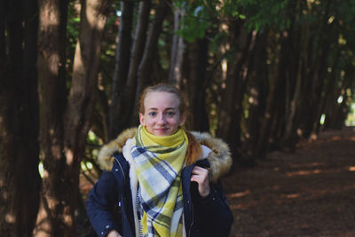 Portrait of smiling woman standing in forest