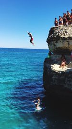 Man jumping over sea against clear sky