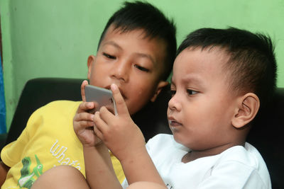 Two boys playing games via smartphone