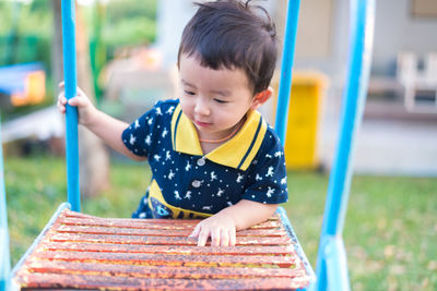 Cute boy playing on slide at playground