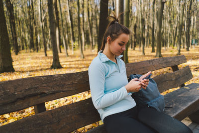 Beautiful girl uses phone for fitness or yoga.