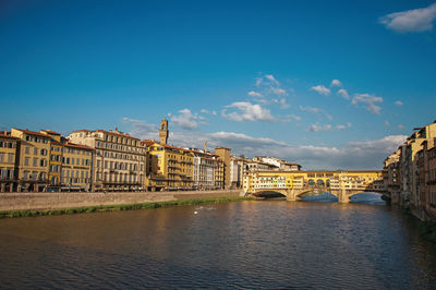 River arno, buildings and the ponte vecchio - bridge - at sunset. in the city of florence, italy.