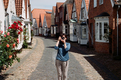 Friends standing on street amidst buildings in city