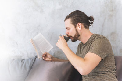 Man having coffee while reading book