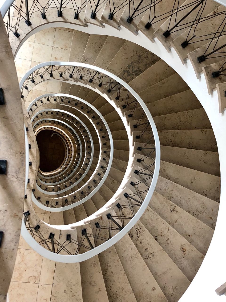 steps and staircases, spiral, staircase, architecture, built structure, spiral staircase, pattern, railing, design, diminishing perspective, no people, indoors, shape, high angle view, directly above, geometric shape, circle, day, architectural feature, absence, directly below, ceiling, concentric