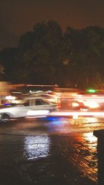 Light trails on road against sky at night