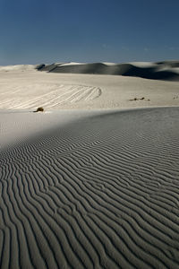 Scenic view of sand dune on beach against sky