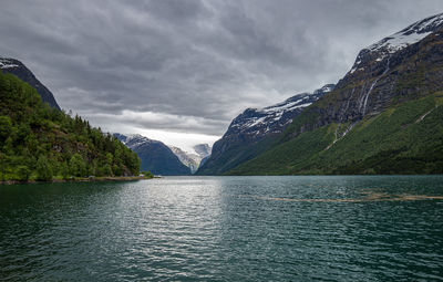 Scenic view of lake by mountains against sky