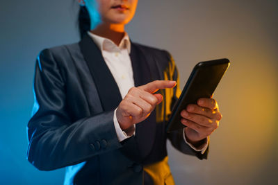 Midsection of man using mobile phone